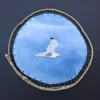 Aquarelle originale de Renaud Prégaldiny artiste peintre aquarelliste. Goéland en vol sur un fond bleu entre ciel et océan. aquarelle tendue sur un cadre rond en baguette de bambou.