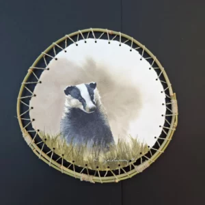 Aquarelle originale de Renaud Prégaldiny artiste peintre aquarelliste. Portrait d'un blaireau, animal paisible représenté dans son environnement et présenté dans un cadre rond en baguette de bambou.